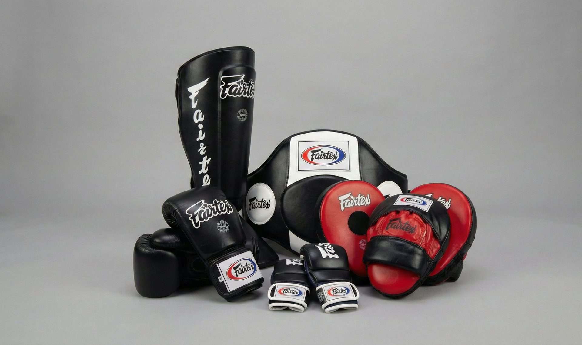 Équipements de Muay Thai Fairtex : Gants de boxe et protège-tibias sur un ring
