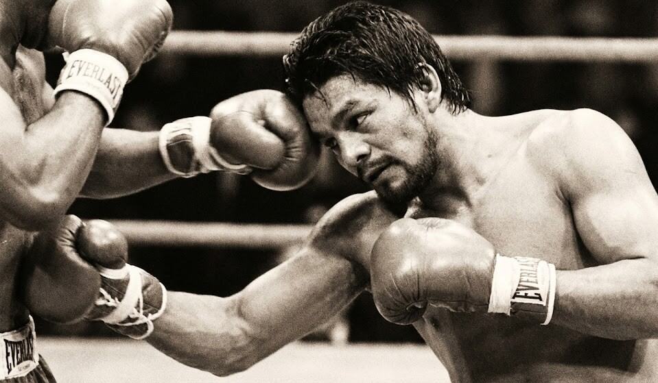 Analyse technique : Roberto Duran collé à son adversaire, esquivant un coup par un mouvement de tête tout en préparant un coup au corps.