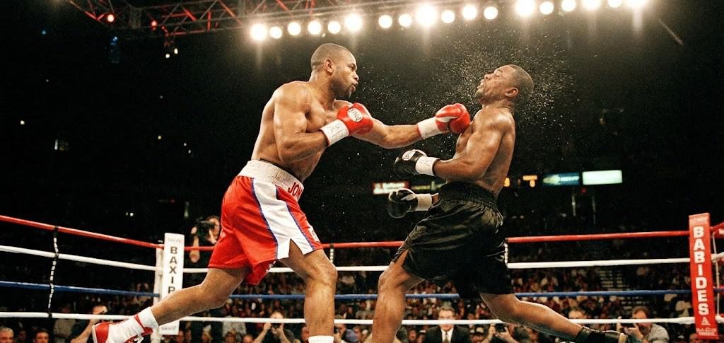 Roy Jones Jr. lançant son fameux crochet gauche en sautant (leaping hook) contre un adversaire.
