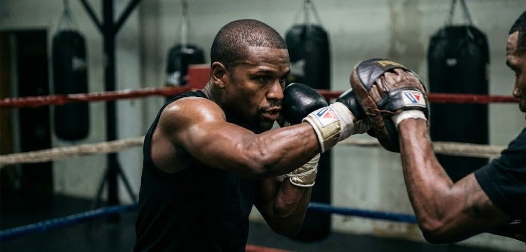 : Analyse technique de la défense de Floyd Mayweather : la position du Shoulder Roll (Philly Shell) pour bloquer les coups avec l'épaule.