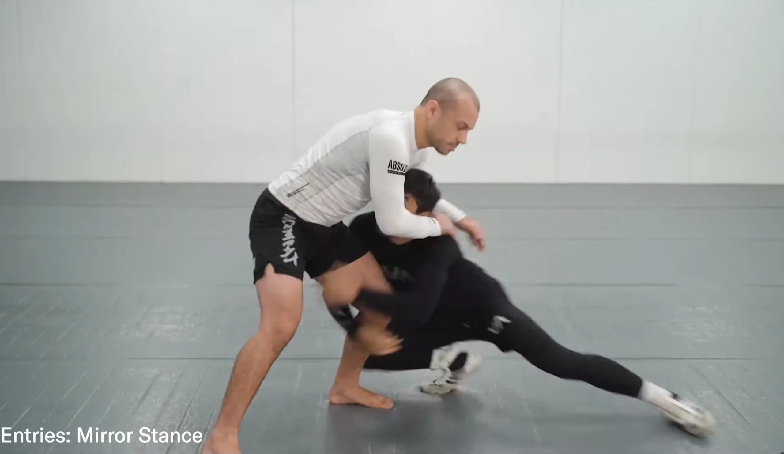 Combattant exécutant un Single Leg Takedown en MMA en verrouillant la jambe et avec une posture parfaite