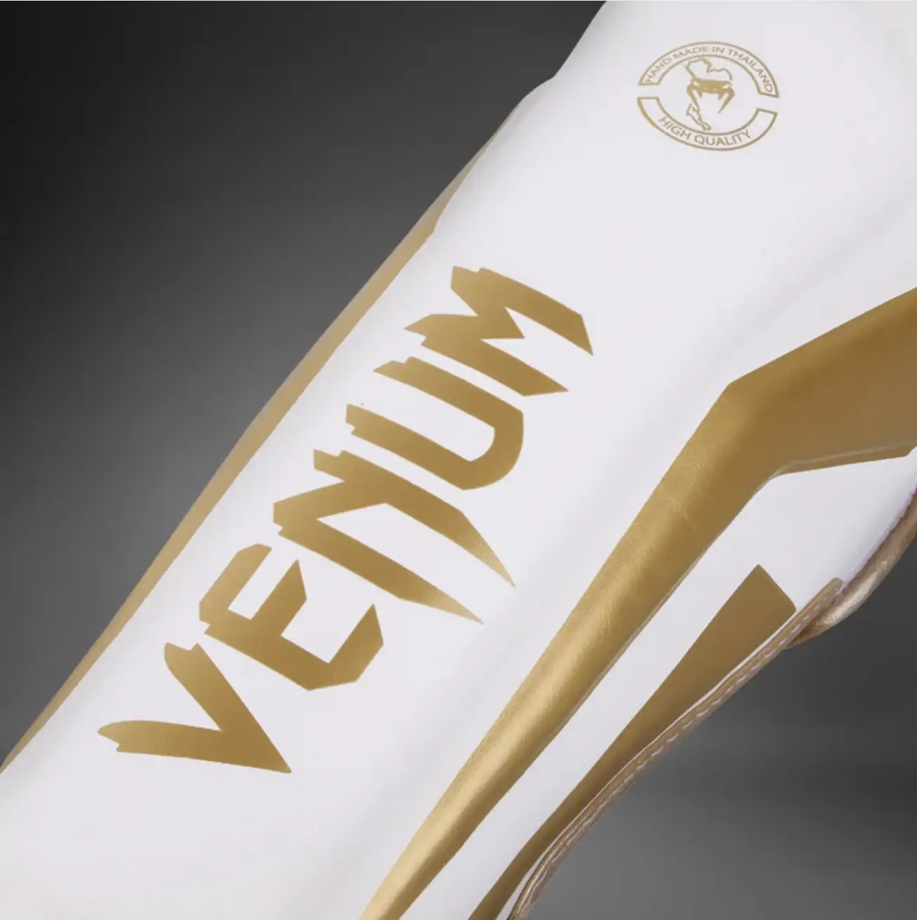 Détails logo Venum gold finitions premium Elite protège tibia