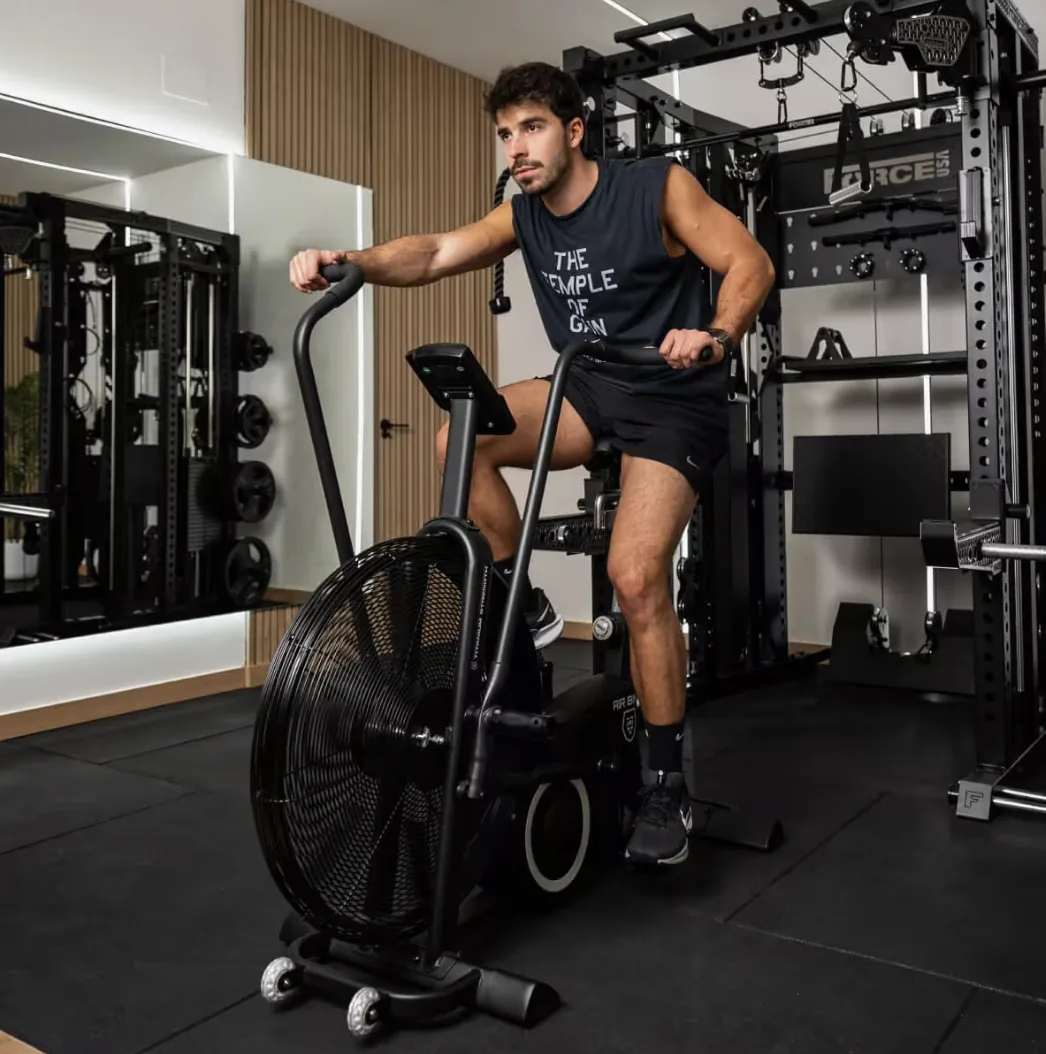 Un pratiquant sur un air bike Titanium Strength